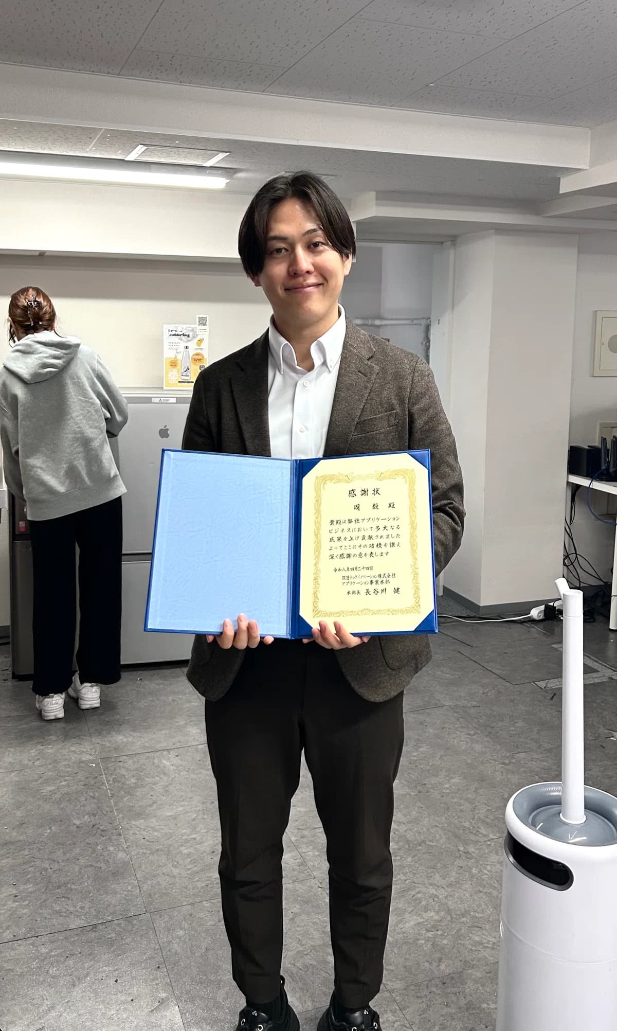 顧客からの感謝状を手にするメンバー