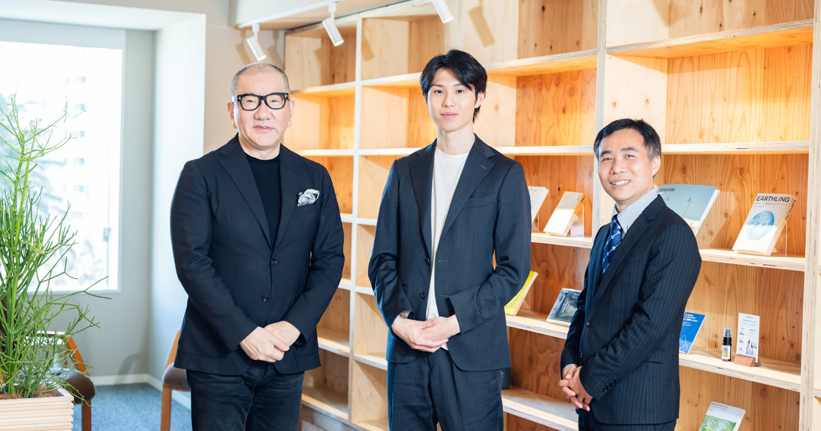 顧問招聘のお知らせに掲載された本棚の前に並ぶ3人の写真